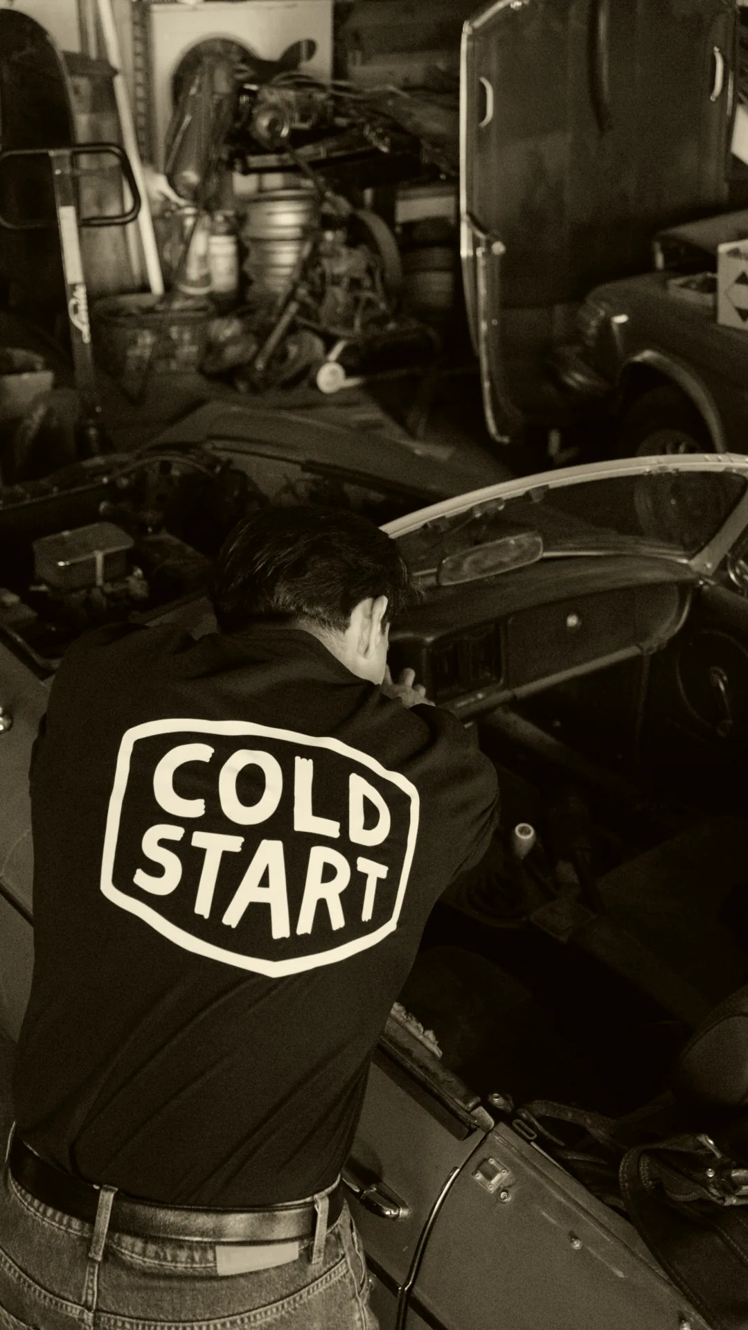 Cold Start jacket in a garage while working on a vintage car
